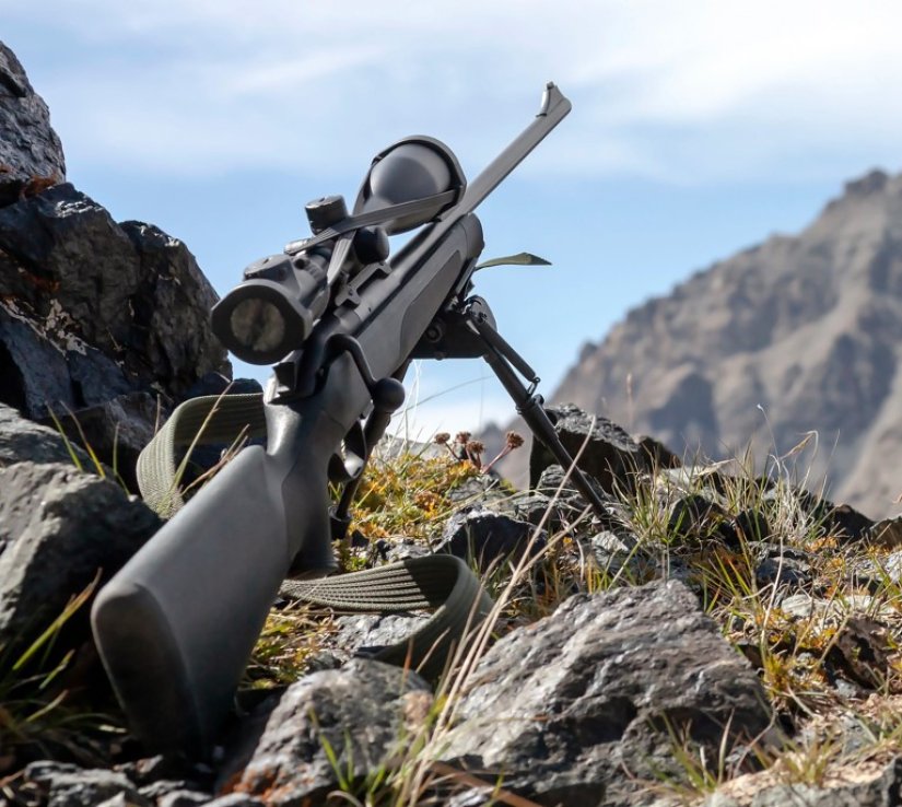 Cazador utilizando bípode plegable montado en rifle de cerrojo